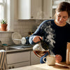 Woman brewing coffee in sunlit kitchen