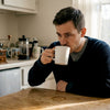 Man tasting coffee in cozy kitchen setting