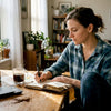 Woman journaling at cozy kitchen coffee tasting setup